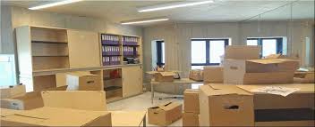 Professional office moving n shifting services in Dhaka, Bangladesh. Picture of a cluttered office with furniture and boxes.